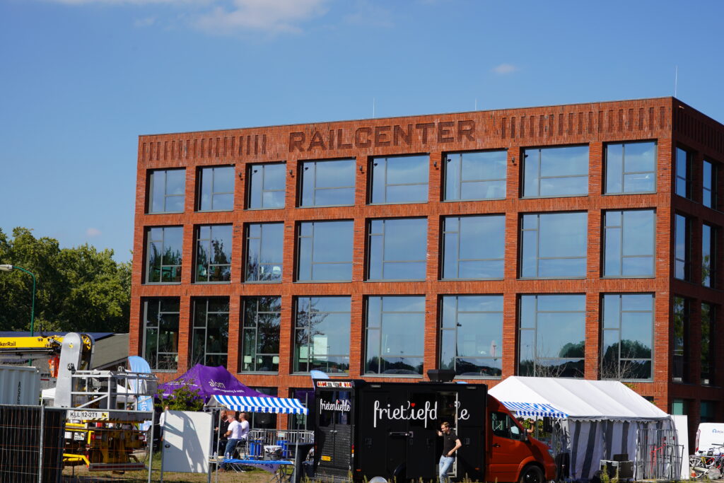 An image of the modern building of the dutch railcenter. The word railcenter is written at the top of the building.