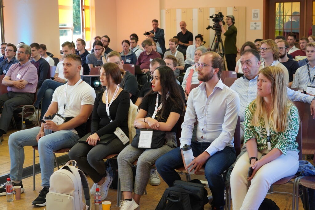 A large group of people sitting in a hall following a presentation